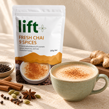 Hot chai latte serving suggestion in a pale ceramic cup beside a Lift Fresh Chai 9 Spices pouch.