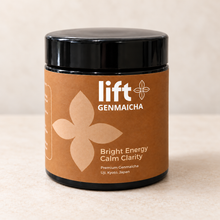 Lift Genmaicha in a black jar with a brown label on a light neutral background