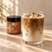Iced hojicha latte serving suggestion in a clear glass with a Lift Hojicha black jar on a warm stone counter.